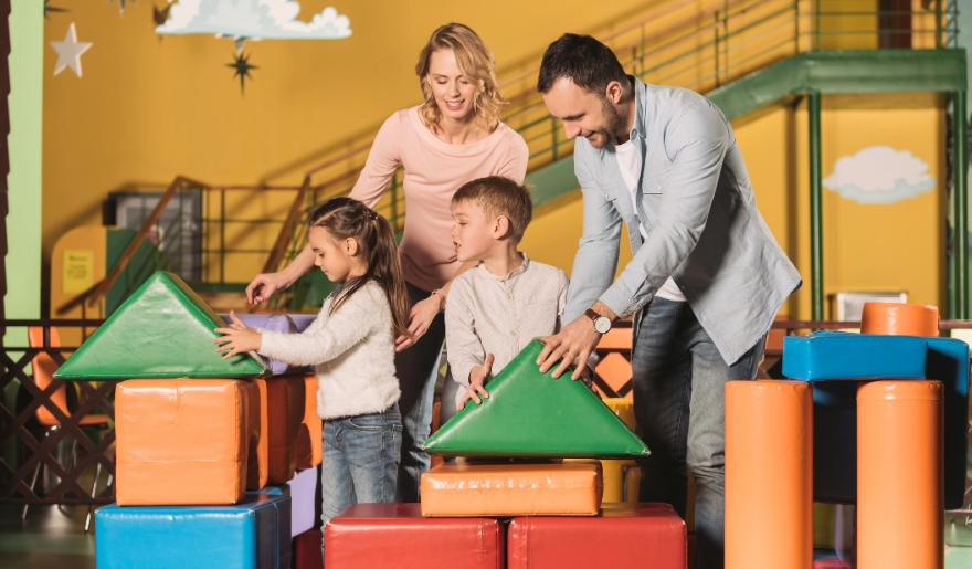 A family engages in block play in a vibrant play area at WonderWorks, showcasing fun activities for kids in Myrtle Beach.