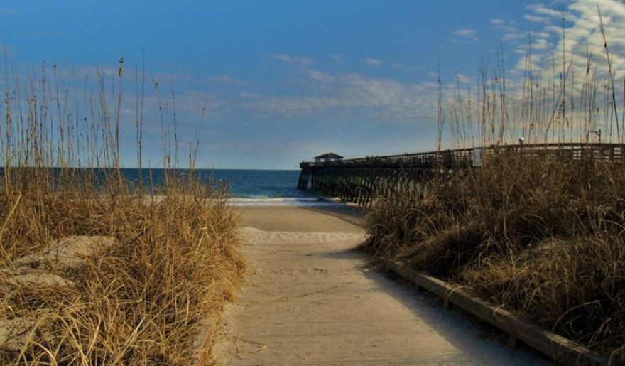 A scenic view of the beach and pier at Myrtle Beach State Park, offering family-friendly outdoor activities.