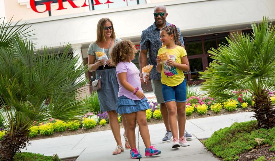 Family of tourist enjoys the food while walking in The Market Common