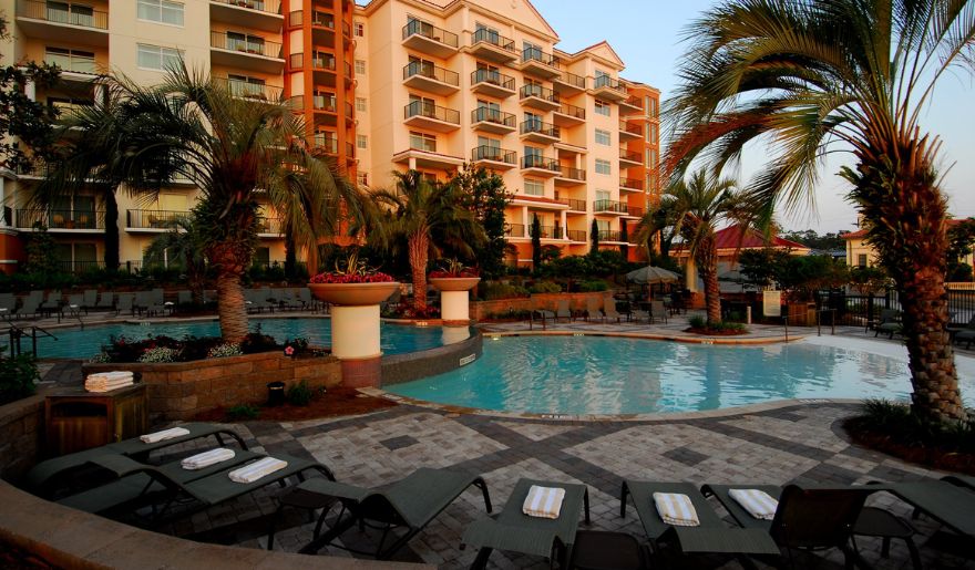 Night time view of the luxury outdoor pool in Marina Inn surrounded by plants and trees