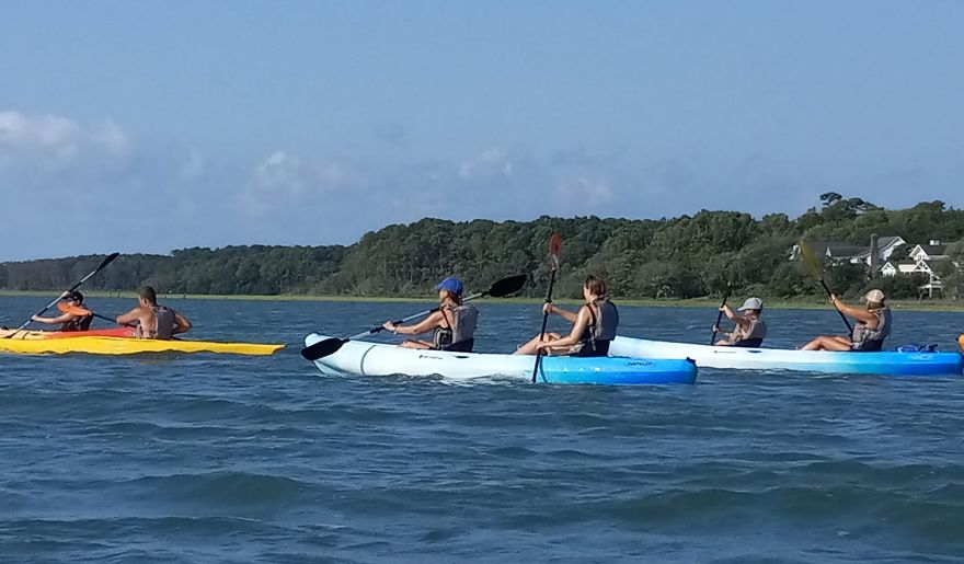 A group of tourists enjoy kayaking on the Waccamaw River during spring season