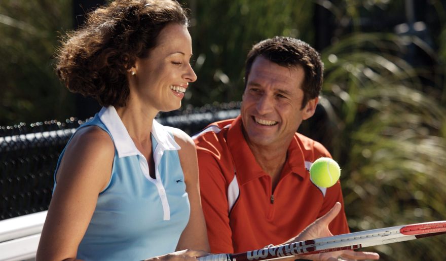 A lovely couple enjoys playing tennis in Myrtle Beach with sunny weather