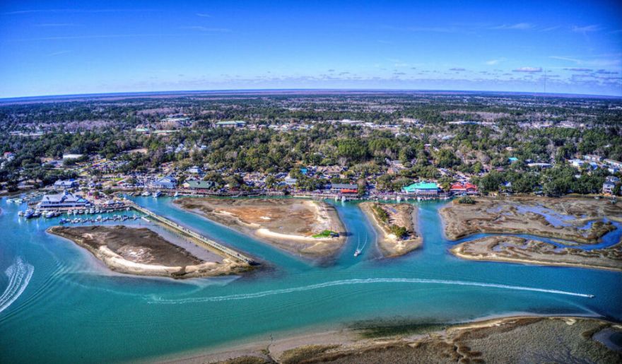 Aerial view of MarshWalk at Murrells Inlet, highlighting a quaint town alongside tranquil waters.