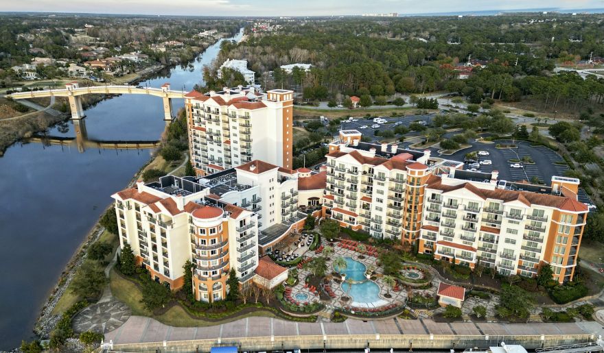 Aerial view of Marina Inn at Grande Dunes alongside a winding river, perfect option to stay during Myrtle Beach Hiking Trails.