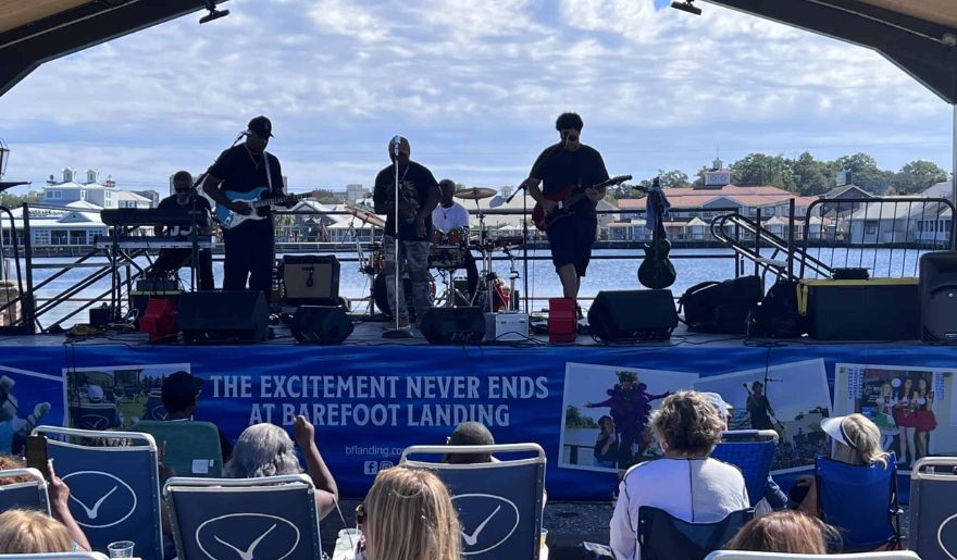 A band performs on stage at Myrtle Beach in October, captivating a lively crowd with their music and energy.