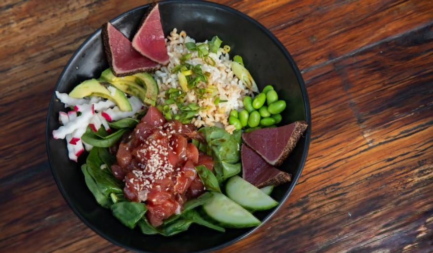 A bowl of sushi featuring tuna, avocado, and greens, highlighting a delicious dining option in Myrtle Beach.