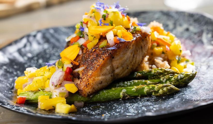 A beautifully arranged plate featuring grilled fish and fresh asparagus, highlighting places to eat in Myrtle Beach,.