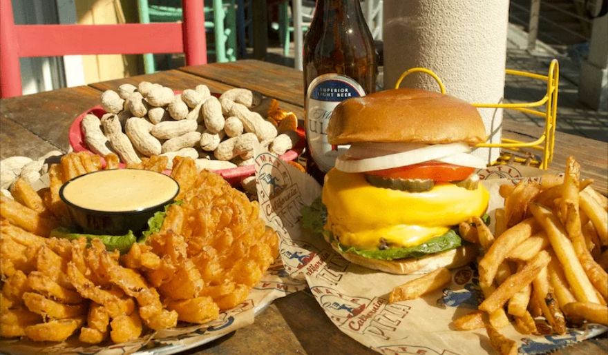 A table set with a delicious burger, crispy fries, and a refreshing beer served by River City Café