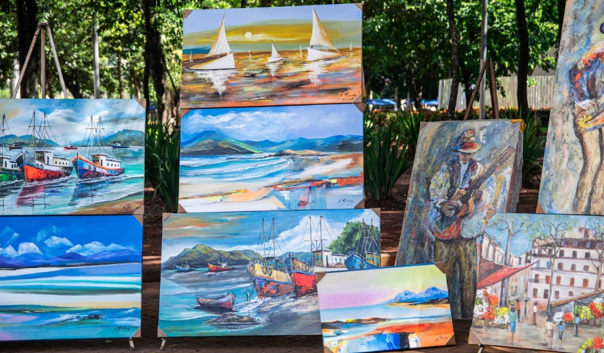 Colorful paintings arranged for viewing at an outdoor market, highlighting Myrtle Beach's artistic offerings in the fall.