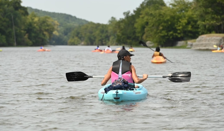 A woman navigates a kayak on a river, showcasing spring adventures in Myrtle Beach.