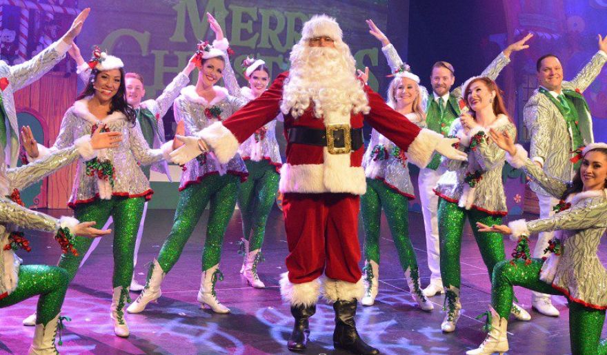 A lively performers dressed in green and red costumes, with Santa Claus, perform during the Myrtle Beach Christmas event.