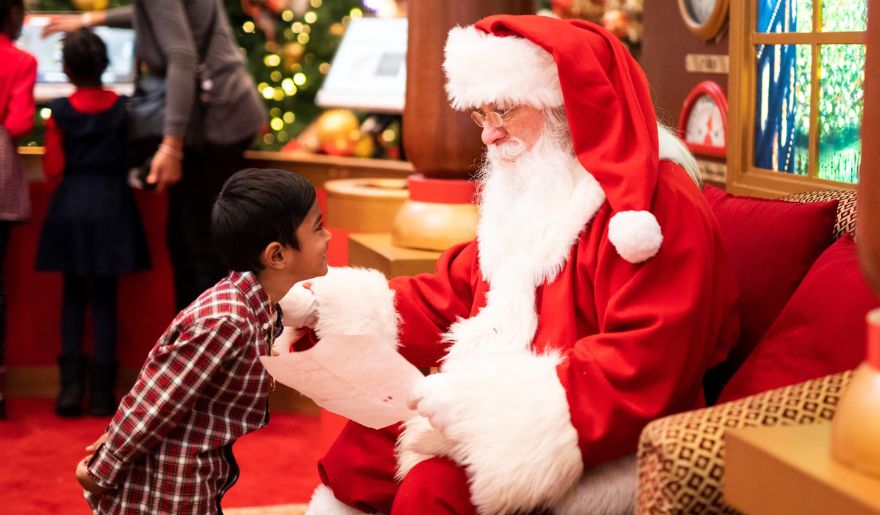 A young boy meet and joyfully interacting with Santa Claus during a Myrtle Beach Christmas event.