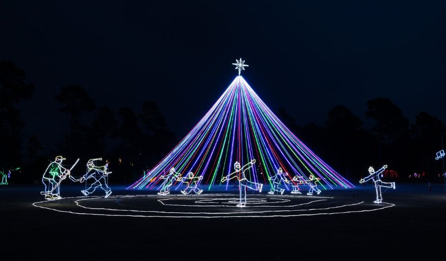 A festive gathering around a glowing Christmas tree at the Great Christmas Light Show in Myrtle Beach, celebrating the season.