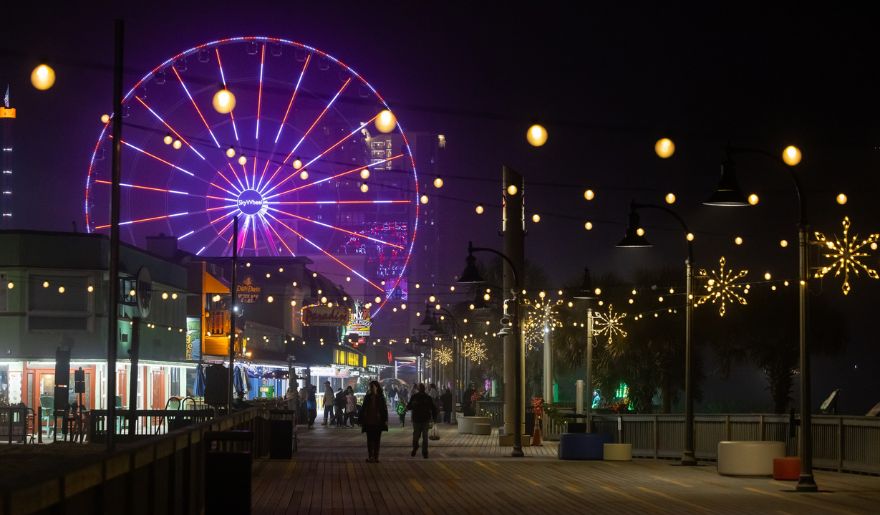 A brightly lit ferris wheel at night, showcasing the festive spirit of Myrtle Beach's Winter Wonderland at The Beach.