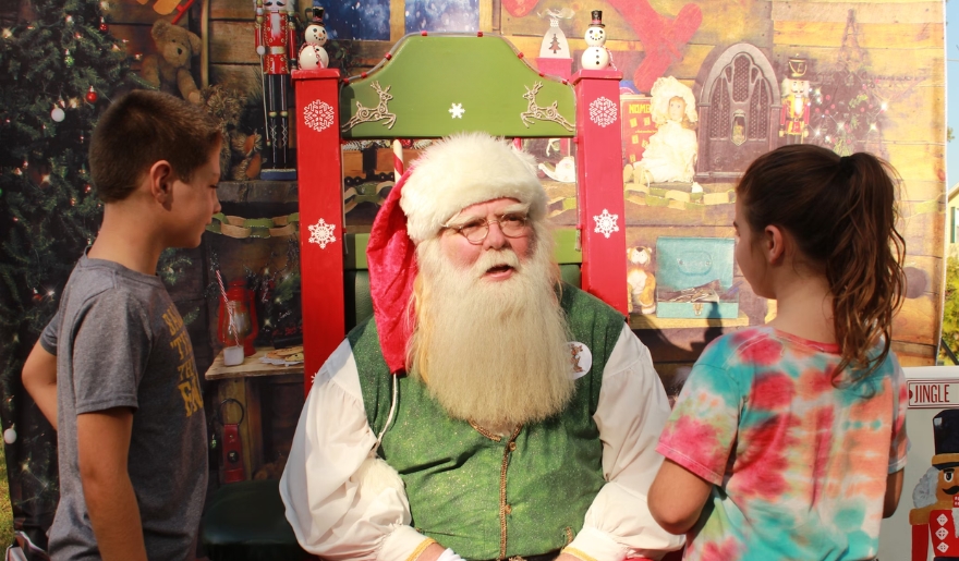 Santa Claus at the Myrtle Beach, smiling with holiday decorations and vibrant background.