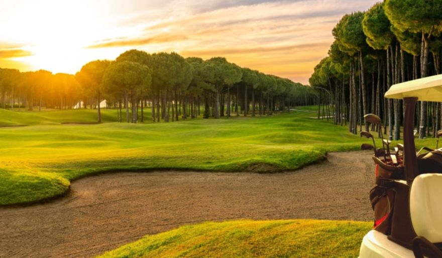 A tranquil sunset over a golf course, highlighting the beauty of Myrtle Beach for a memorable winter retreat.