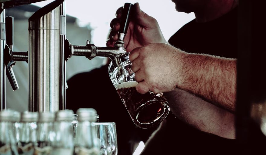 A man skillfully pours beer into a glass, highlighting the craft beverage culture of Myrtle Beach in winter.