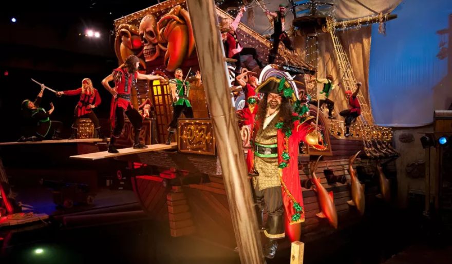 A bustling pirate ship with crew members, including a man in a pirate costume, highlighting the excitement of  Pirates Voyage Dinner & Show at Myrtle Beach.