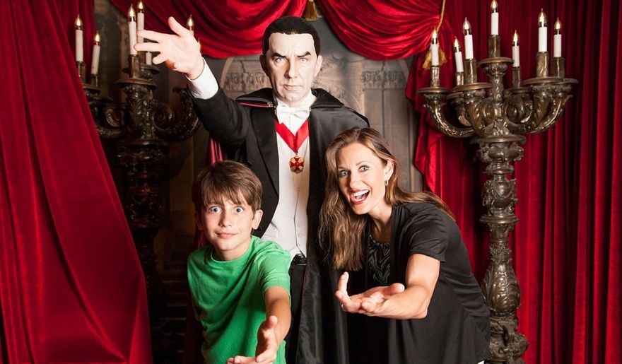 A woman and her son stand beside a vampire statue at the Hollywood Wax Museum in Myrtle Beach, showcasing winter fun.