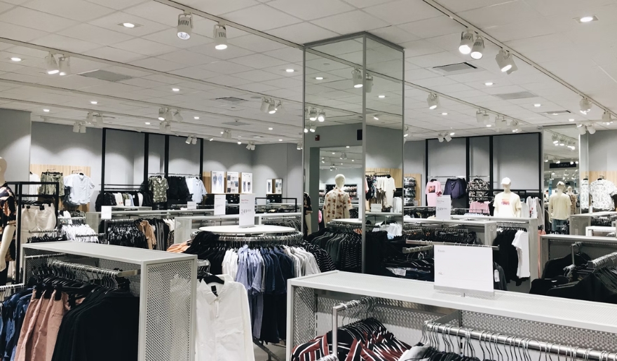Interior of a clothing store at Tanger Outlets, showcasing various winter clothes displayed on racks.