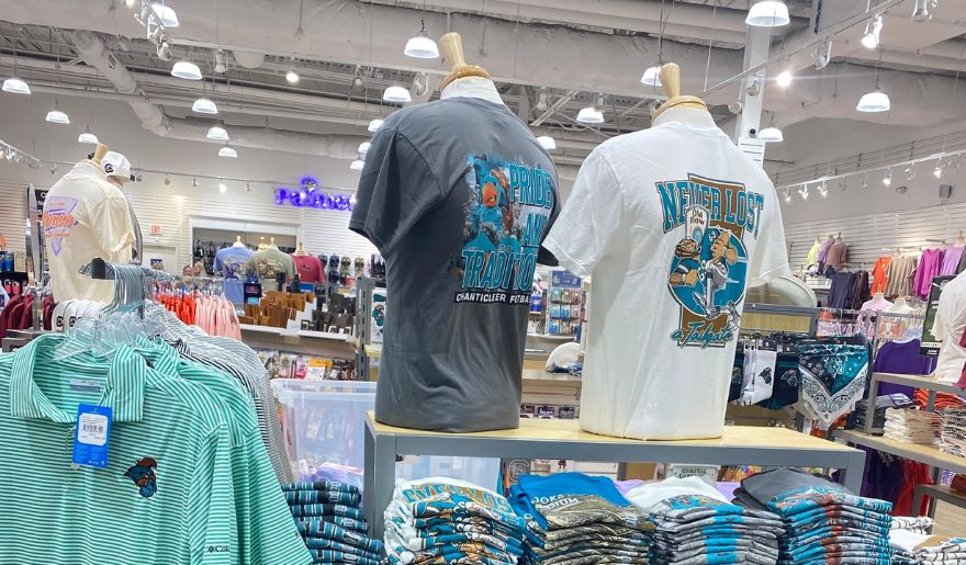 A vibrant store at Coastal Grand Mall showcasing a variety of shirts on display for shoppers to explore.