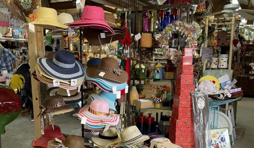 A vibrant store display featuring a variety of hats and merchandise at Hudson’s Surfside Flea Market in Myrtle Beach.