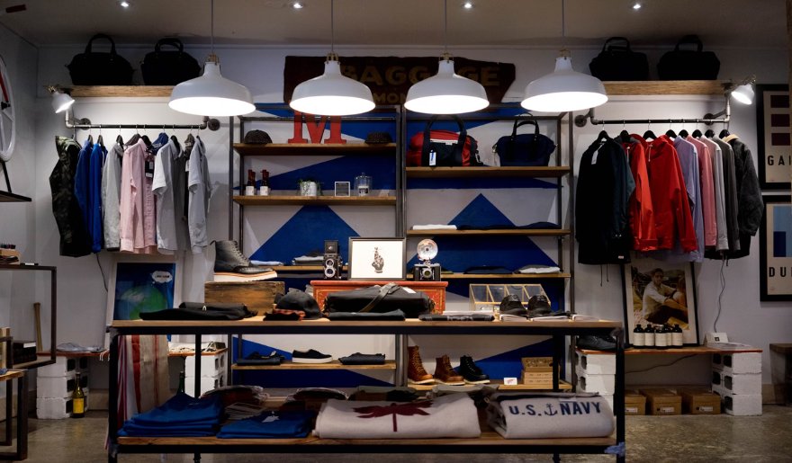 Inside a clothing store at Village Square Shopping Center, featuring neatly arranged clothes on racks and shelves for customers.