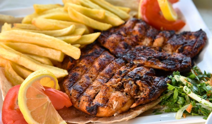 Delicious grilled chicken with French fries on a plate, highlighting Bubba’s Fish Camp & Smokehouse in Myrtle Beach.