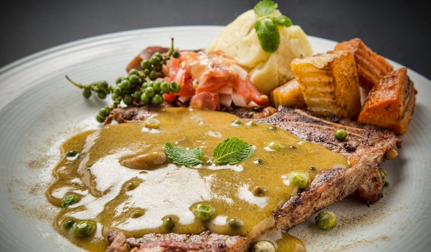 A delicious meal of steak, potatoes, and gravy served on a plate at Café Old Vienna, a dining spot in Myrtle Beach.