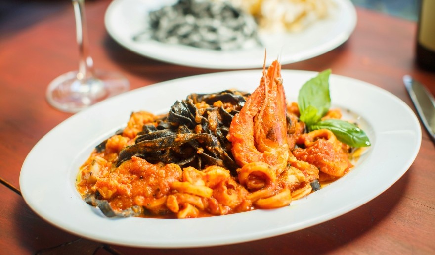 A delicious plate of shrimp pasta with sauce displayed on a table at Ciao Italian Restaurant, Myrtle Beach.