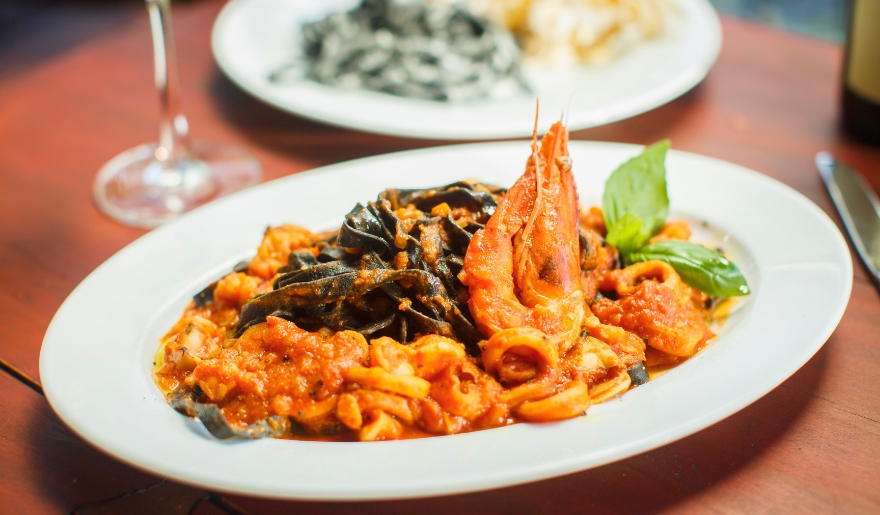 A delicious plate of shrimp pasta with sauce displayed on a table at Ciao Italian Restaurant, Myrtle Beach.