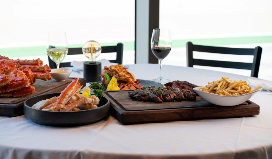 A beautifully arranged table featuring diverse food options and wine, highlighting The Melting Pot's offerings in Myrtle Beach.