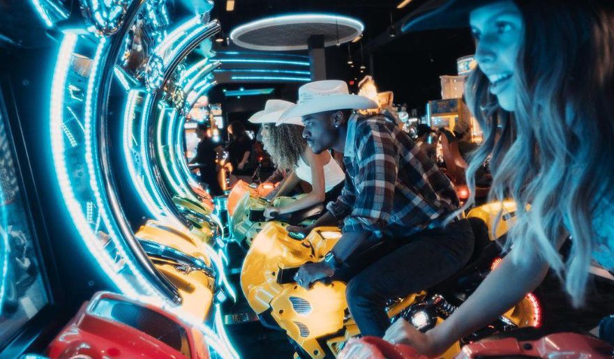 A group of individuals enjoying a game machine at Dave & Buster’s during Myrtle Beach New Year’s Eve celebration.