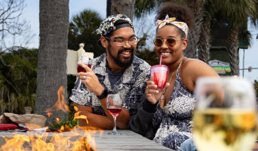 A couple enjoying a delightful meal and wine at Duplin Winery, capturing a romantic moment in Myrtle Beach's vibrant atmosphere.