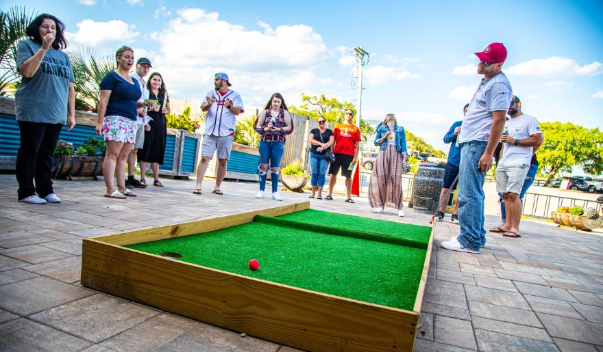 Couples gather around a miniature golf course at Murrells Inlet MarshWalk, a charming destination in Myrtle Beach.