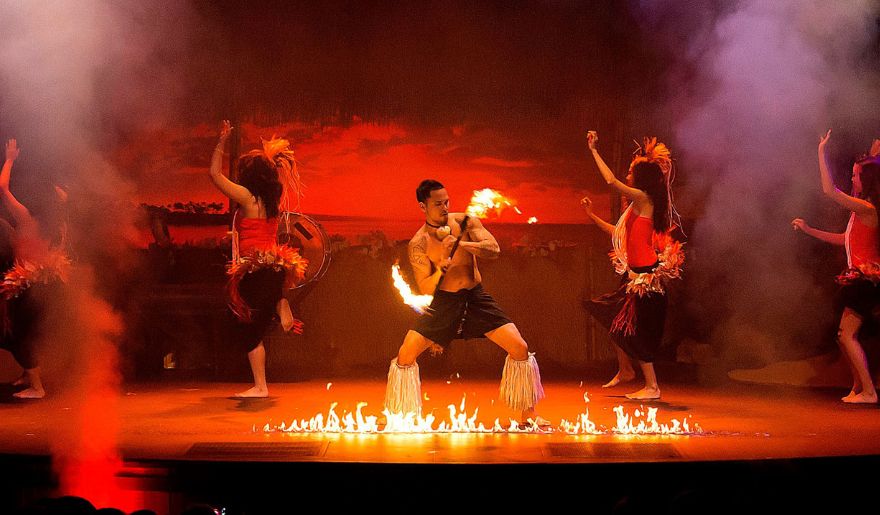 A lively Polynesian fire luau featuring dancers on stage, skillfully blending movement and fire for an enchanting performance.