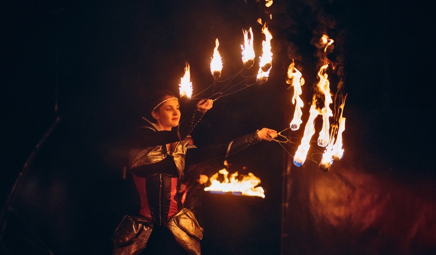 A woman dressed in traditional attire showcases fire torches at a Polynesian Fire Luau event in Myrtle Beach perfect for couples.