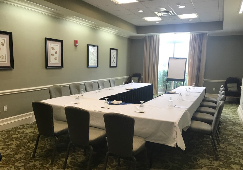 A well-equipped conference room featuring tables and chairs set for a meeting, highlighting Myrtle Beach's modern meeting space.