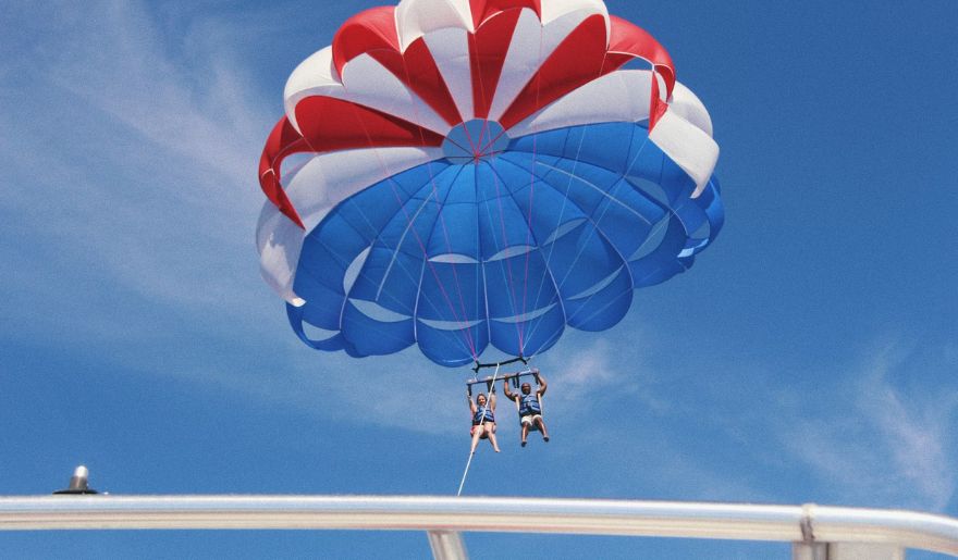 Two people parasails over Myrtle Beach, enjoying their spring break.