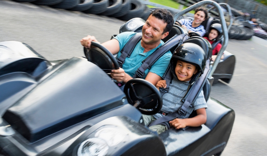 A family enjoying a go-kart ride at Broadway Grand Prix in Myrtle Beach, smiling and having fun together.