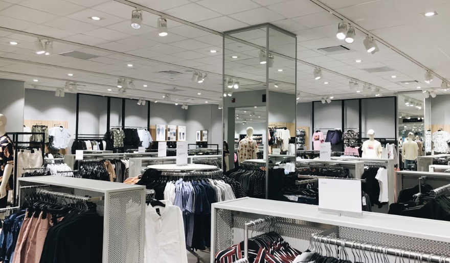 Interior of a clothing store at Coastal Grand Mall, showcasing clothes neatly arranged on racks for customers.