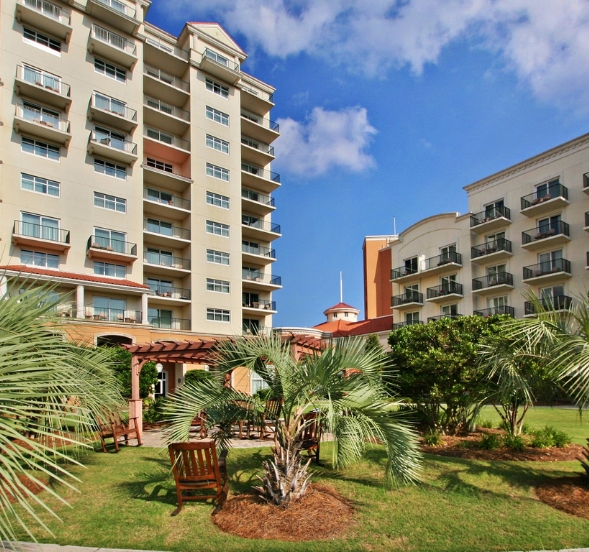 A scenic view of a beach resort in Marina Inn, featuring three-bedroom condos available for rent.