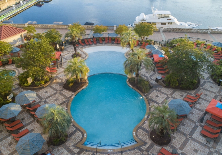 A picturesque pool with lounge chairs and umbrellas in Marina Inn, showcasing year-round heated condos in Myrtle Beach.