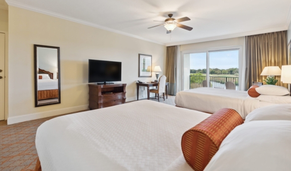 Cozy hotel room with two beds and a television, perfect for guests in Marina Inn with 4-bedroom penthouse.