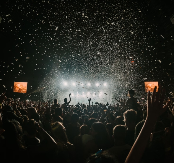 A lively crowd at a concert celebrating the Carolina Country Music Fest 2025, with colorful confetti cascading down.