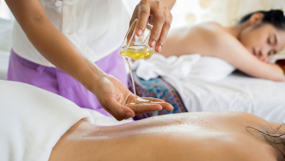 A woman enjoys a relaxing oil massage on her back at Marina Inn