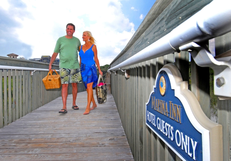 man and woman walk together on a wooden bridge, celebrating their honeymoon in an exclusive location at Myrtle Beach, SC.