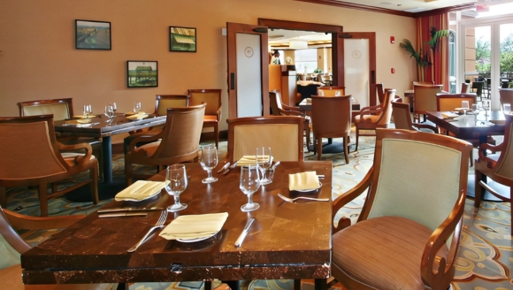 A spacious restaurant featuring tables and chairs arranged centrally, showcasing WaterScapes Dining at Myrtle Beach Condo Rentals.