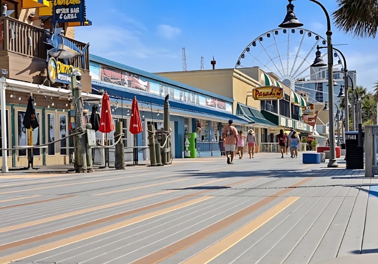 People walking along a lively boardwalk at Myrtle Beach Family Resort, surrounded by nearby family attractions.