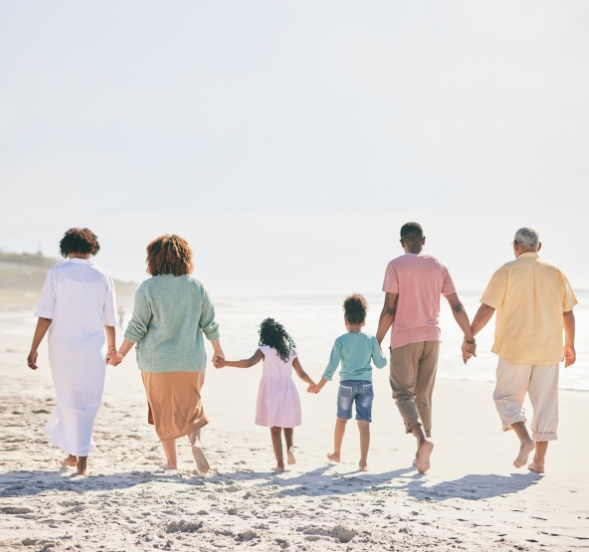 A joyful family walks hand in hand on the beach at Myrtle Beach Family Resort, creating cherished memories.